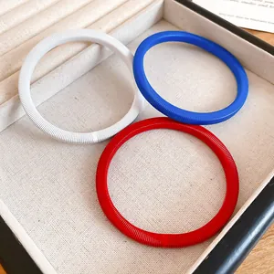 Set di tre eleganti bracciali con trama a molla a coste in rosso, bianco e blu.