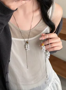 Detail showing the elegant grape pearl necklace and natural stone on an Asian model