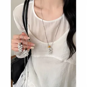 Detailed view of Korean style grape pearl necklace with natural stones worn by model