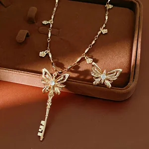 Detailopname van een goudkleurige sleutelketting met vlindervleugels en heldere zirkoon.