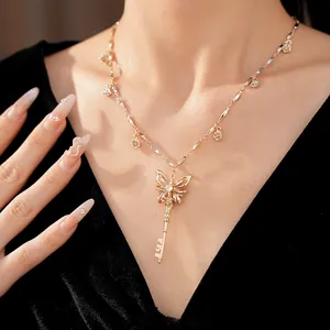 Detailopname van gouden vlinder sleutel hanger ketting met zirkoon en bloembedels