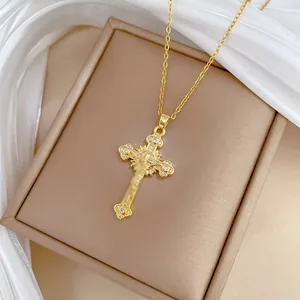 Elegant gold cross pendant necklace with sparkling zircon crystals on silk background