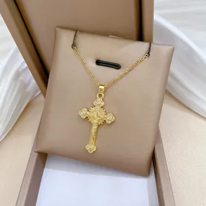 Detailed close-up of a golden cross pendant necklace with sparkling white zircons