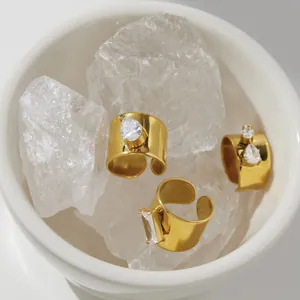 Detailopname van goudkleurige titaniumstalen ringen met zirkonia op kristallen