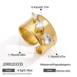 Detailweergave van een gouden roestvrijstalen brede ring met drie zirkonia's.