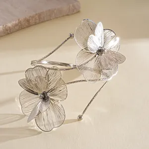 Detailed view of silver filigree flower petals on elegant metallic open arm cuff