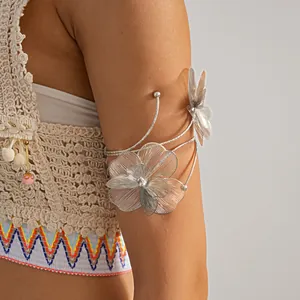 Detailed close-up view of a silver wire-woven flower arm cuff on a model's upper arm