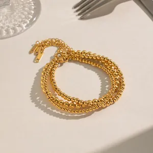 Three-layer 18K gold plated bead bracelet with lobster clasp on elegant stone background