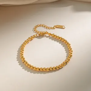 Detailed close-up of 18K gold-plated beaded steel bracelet with lobster clasp and extension chain