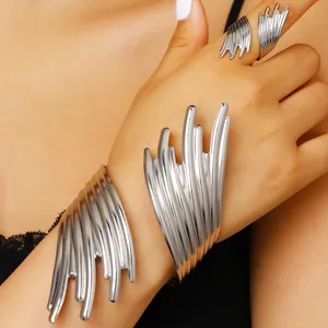 Ensemble bracelet et bague argentés avec lignes sculpturaux abstraites sur modèle