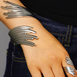 Gros plan d'un ensemble bracelet et bague en argent sculpté aux lignes abstraites