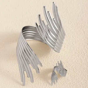 Gros plan sur l'ensemble bracelet et bague argenté aux lignes sculpturales abstraites