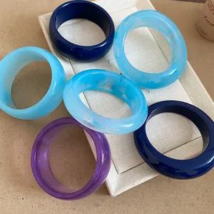 Set di bracciali in resina con dettagli marmorizzati e glitter su un supporto bianco