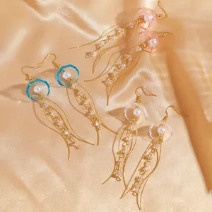 Vue détaillée de trois paires de boucles d'oreilles méduse en rose, bleu et blanc nacré