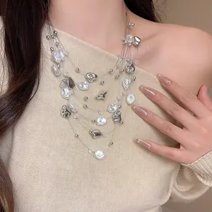 Primo piano di una collana vintage a più strati con perle irregolari e perline di cristallo