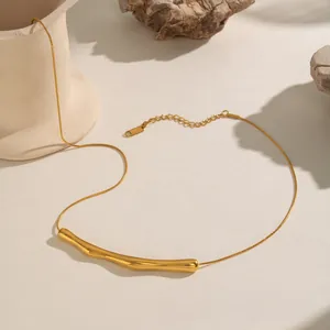 Macro shot of 18K gold plated wavy bar necklace detail with lobster clasp and snake chain