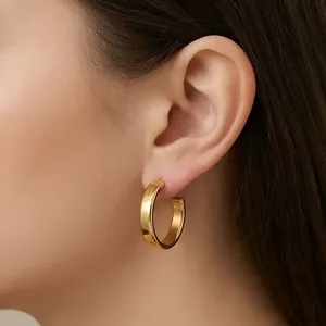 Polished gold thick C-shaped hoop earrings for women in stainless steel, model view