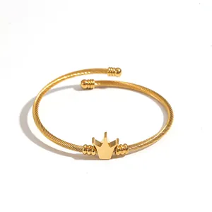 Dettaglio ravvicinato di un bracciale minimalista in acciaio al titanio dorato con corona