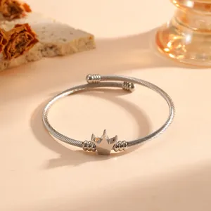 Dettaglio di un ciondolo a corona in acciaio inossidabile su un bracciale a cavo intrecciato