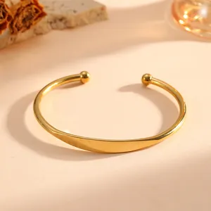 Vista dettagliata di un elegante bracciale rigido in acciaio al titanio dorato con sfere