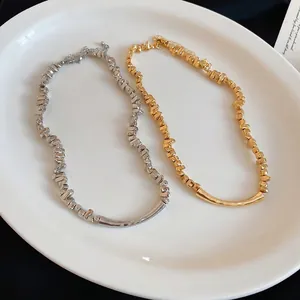 Elegante ketting met onregelmatige metalen kralen in goud- en zilverlook voor dames.