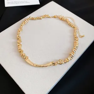 Macro-weergave van onregelmatige geometrische metalen kralen op een gouden ketting
