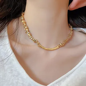 Elegante gouden onregelmatige grove metalen ketting gedragen door model, detail