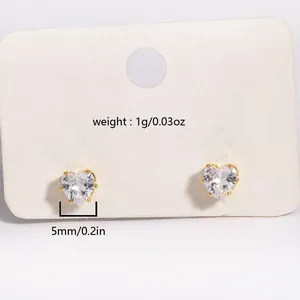 Detail of 5mm heart-shaped zircon earrings with gold-plated prong setting on display card