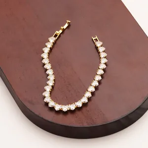 Macro detail of a gold plated heart-shaped cubic zirconia bracelet with a folding clasp