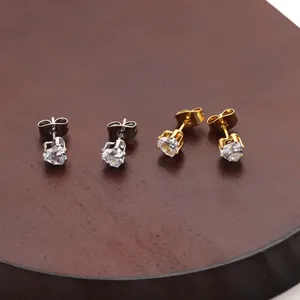 Close-up of heart-shaped zircon stud earrings in gold and silver with prong settings