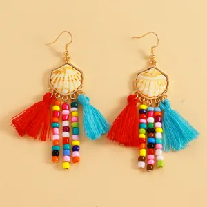 Vue détaillée des boucles d'oreilles coquillage boho avec perles et glands colorés.