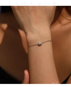 Close-up view of an elegant S925 sterling silver bracelet with oval moissanite on a wrist