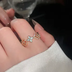 Elegante anello a fiore in oro rosa con cristalli scintillanti e dettagli in smalto blu