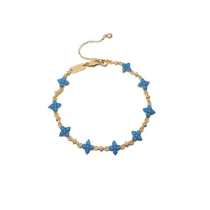 Elegante bracciale a catena in oro con fiori a quattro petali in resina blu e cristalli