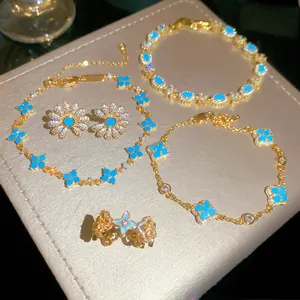 Dettaglio di un elegante set di gioielli con fiori in resina turchese e oro dorato