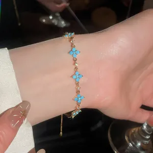 Vista dettagliata di un elegante bracciale a fiori in oro con pietre di resina turchese al polso