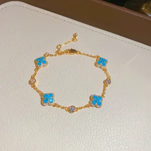 Primo piano dettagliato di un elegante bracciale a fiori in oro con resina blu e cristalli