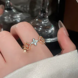 Primo piano di un elegante anello a fiore in oro rosa con resina e pietre luccicanti.