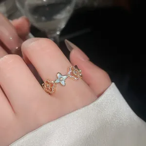 Primo piano di un elegante anello in oro rosa con un fiore in resina blu e corone