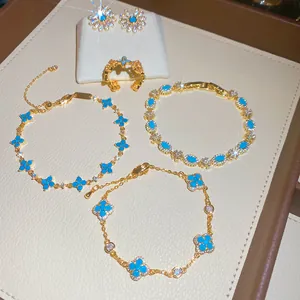 Elegante set di gioielli con fiori in resina blu, bracciali e anelli con finitura oro