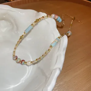 Dettaglio collana di perline in acciaio inox con finiture in blu e oro elegante