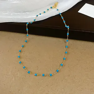 Vista dettagliata della chic collana in acciaio inossidabile dorato con perline blu