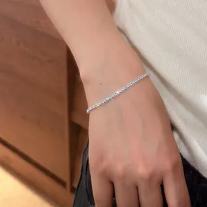 Detailed shot of a delicate silver bracelet with light blue and clear zircon stones.