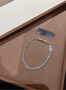 Detail shot of elegant silver tennis bracelet featuring lake blue and clear cubic zirconia