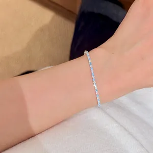 Close-up of elegant lake blue and clear zirconia round stone tennis bracelet on wrist