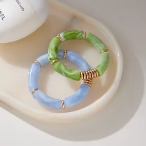 Close-up of resin bamboo-joint bracelets with gold-plated spacers in green and blue.