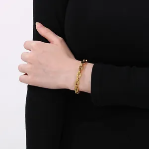 Bracelet élégant à maillons grain de café en acier inoxydable doré porté au poignet