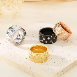 Wide band titanium steel rings with scattered rhinestone patterns in four colors.
