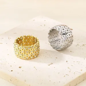 Detailed view of hollowed titanium steel wide rings with inlaid zircon on stone slab