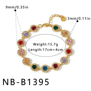 Detalle de pulsera de acero inoxidable dorada con piedras preciosas de colores y strass